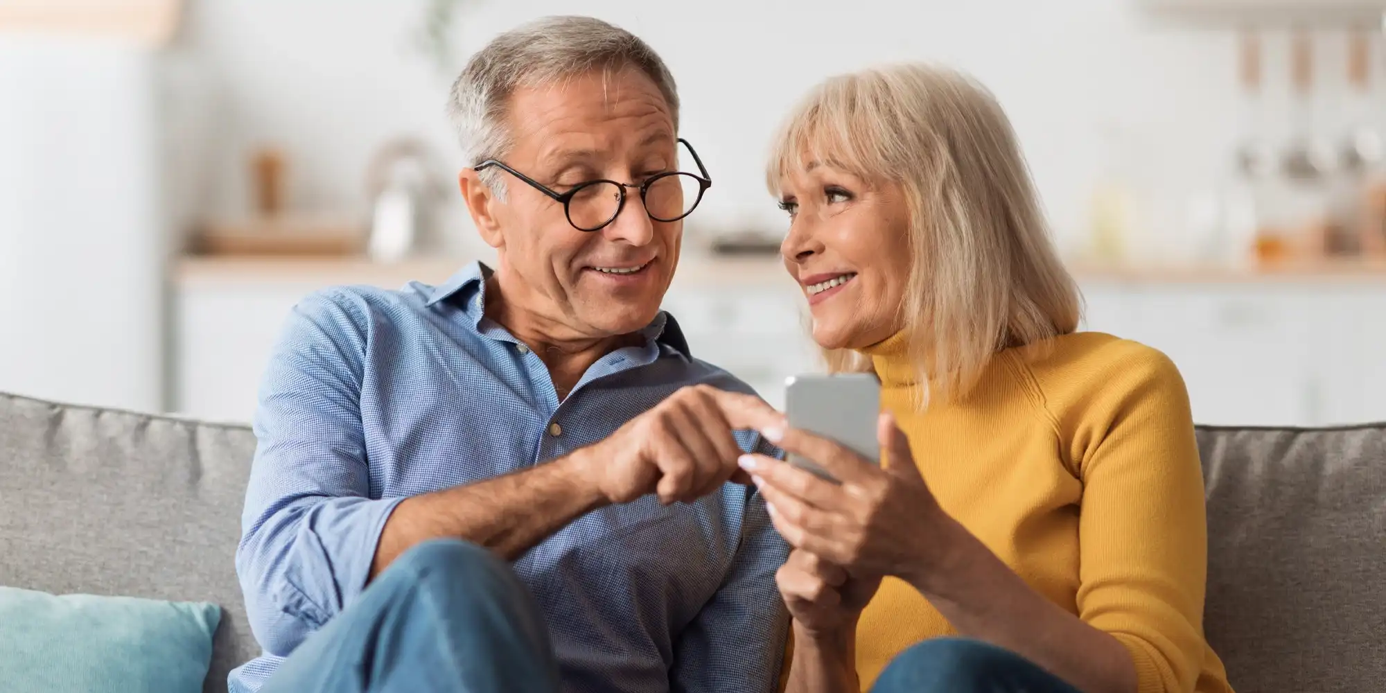 senior couple relaxing together and viewing social media on her phone